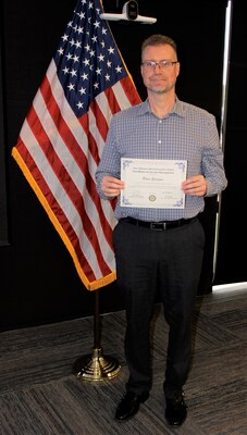 Brian Spragins, an Information Technology (IT) Specialist for Naval Information Warfare Center Atlantic, poses with his Excellence in Service Award from the New Orleans Federal Executive Board (FEB) following an award ceremony June 13 at the U.S. Department of the Interior Bureau of Safety and Environmental Enforcement New Orleans Office. Spragins received an Honorable Mention for Mission Support Excellence.