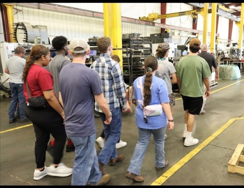 Students walk through a factory