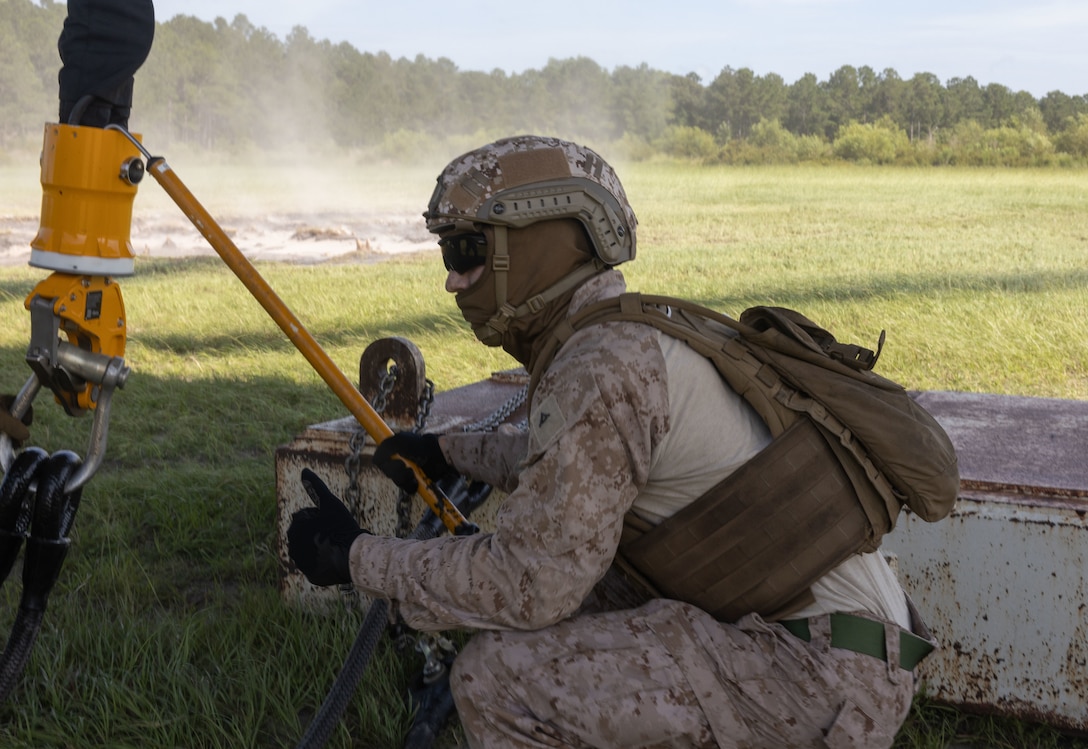 A U.S. Marine with 2nd Distribution Support Battalion, Combat Logistics Regiment 2, 2nd Marine Logistics Group, connects a grounding rod during helicopter support team operations at Tactical Landing Zone Condor on Camp Lejeune, North Carolina, July 18, 2024. 2nd DSB conducted the training to prepare Marines to manage activities at landing zones; facilitate the pickup, movement, and landing of helicopter-borne troops, equipment, and supplies. (U.S. Marine Corps photo by Lance Cpl. Franco Lewis)