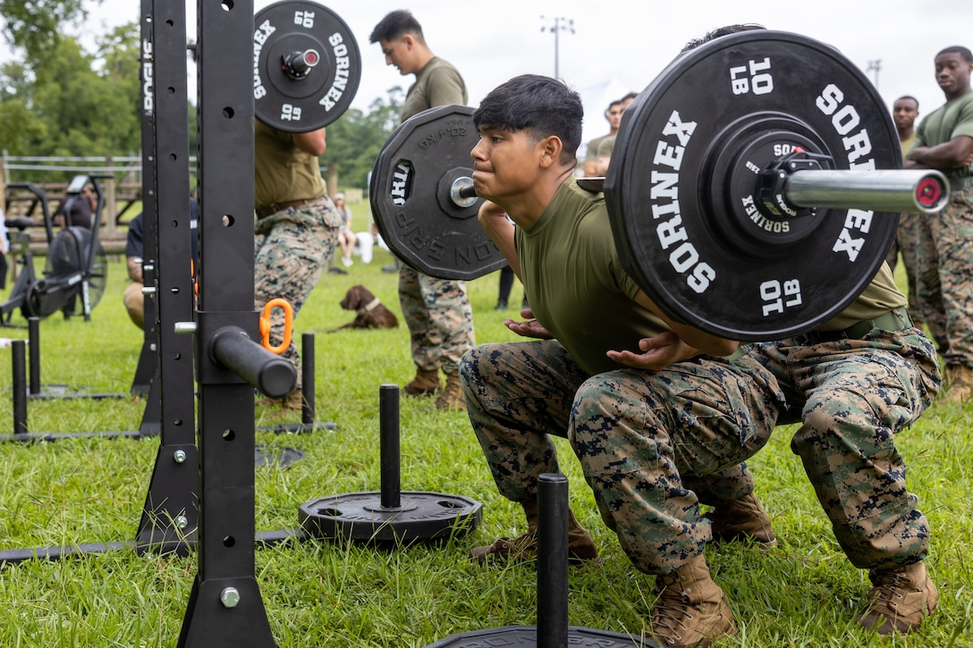 A U.S. Marine with 2nd Marine Logistics Group conducts barbell squats during the Fittest of the 2nd MLG event hosted by the 2nd MLG Human Performance Center on Camp Lejeune, North Carolina, July 19, 2024. Teams from across 2nd MLG regiments and battalions competed for the title of “Fittest of 2nd MLG” in order to promote physical fitness, camaraderie, and friendly competition. (U.S. Marine Corps photo by Lance Cpl. Christian Salazar)