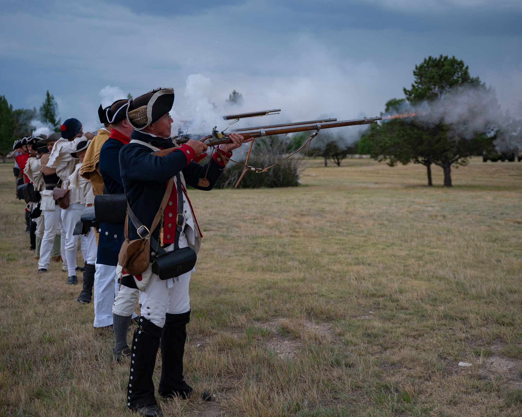Historical reenactors fire display weapons.
