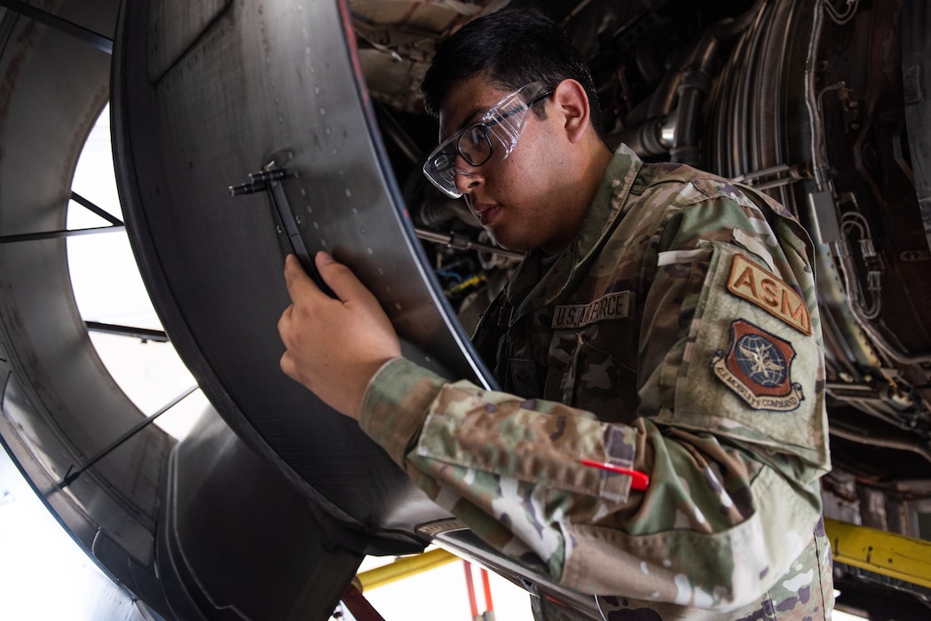Airman performing maintenance on a door latch for a C-17