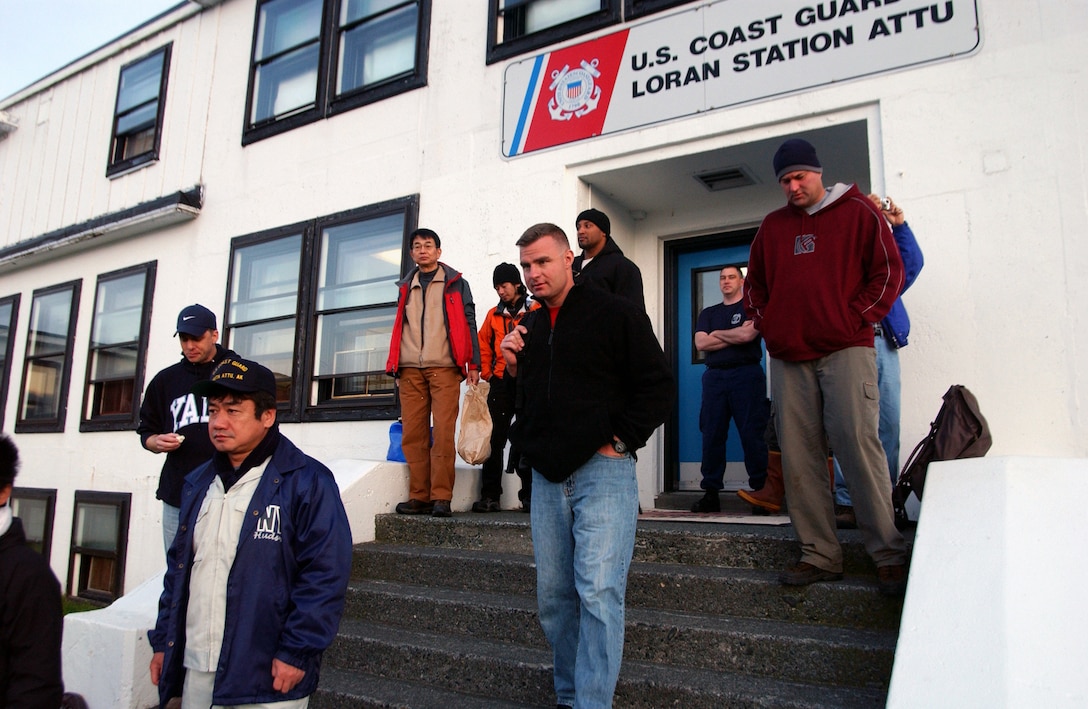 Coast Guardsmen from Loran Station Attu, representatives of the Japanese Government, U.S. Fish and Wildlife service and U.S. Department of Defense gather in front of the Loran Station.