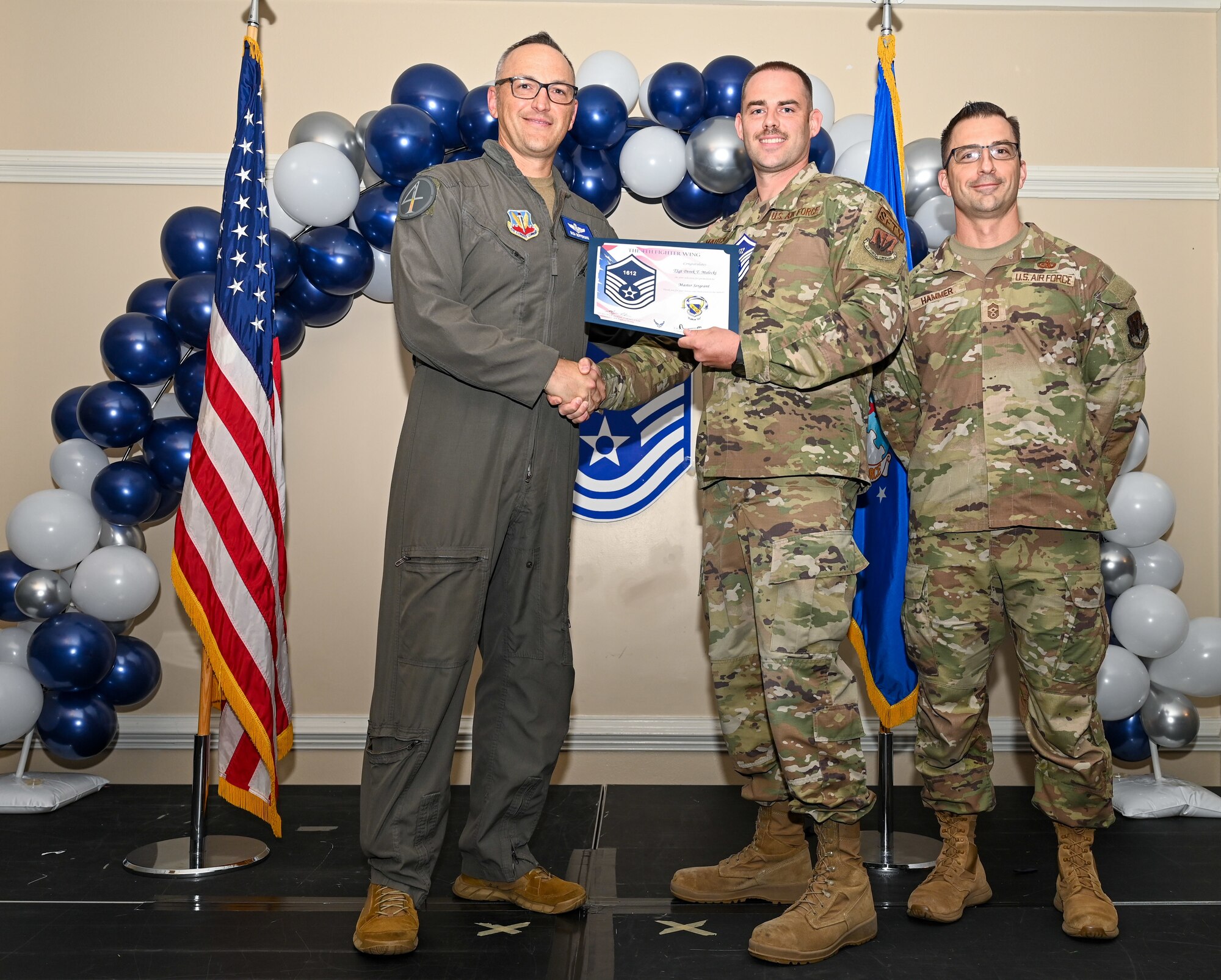 U.S. Air Force Col. Steven Bofferding, 4th Fighter Wing deputy commander (left), and Chief Master Sgt. Paul Hammer, 4 FW command chief, present a certificate to Master Sgt. select Derek Malecki (center), 4 FW Wing Safety flight safety non-commissioned officer, during a Master Sergeant Release Ceremony at Seymour Johnson Air Force Base, North Carolina, June 6, 2024. A total of 5,500 Airmen were promoted among a pool of 29,497 across the Air Force.  (U.S. Air Force photo by Airman Rebecca Tierney)