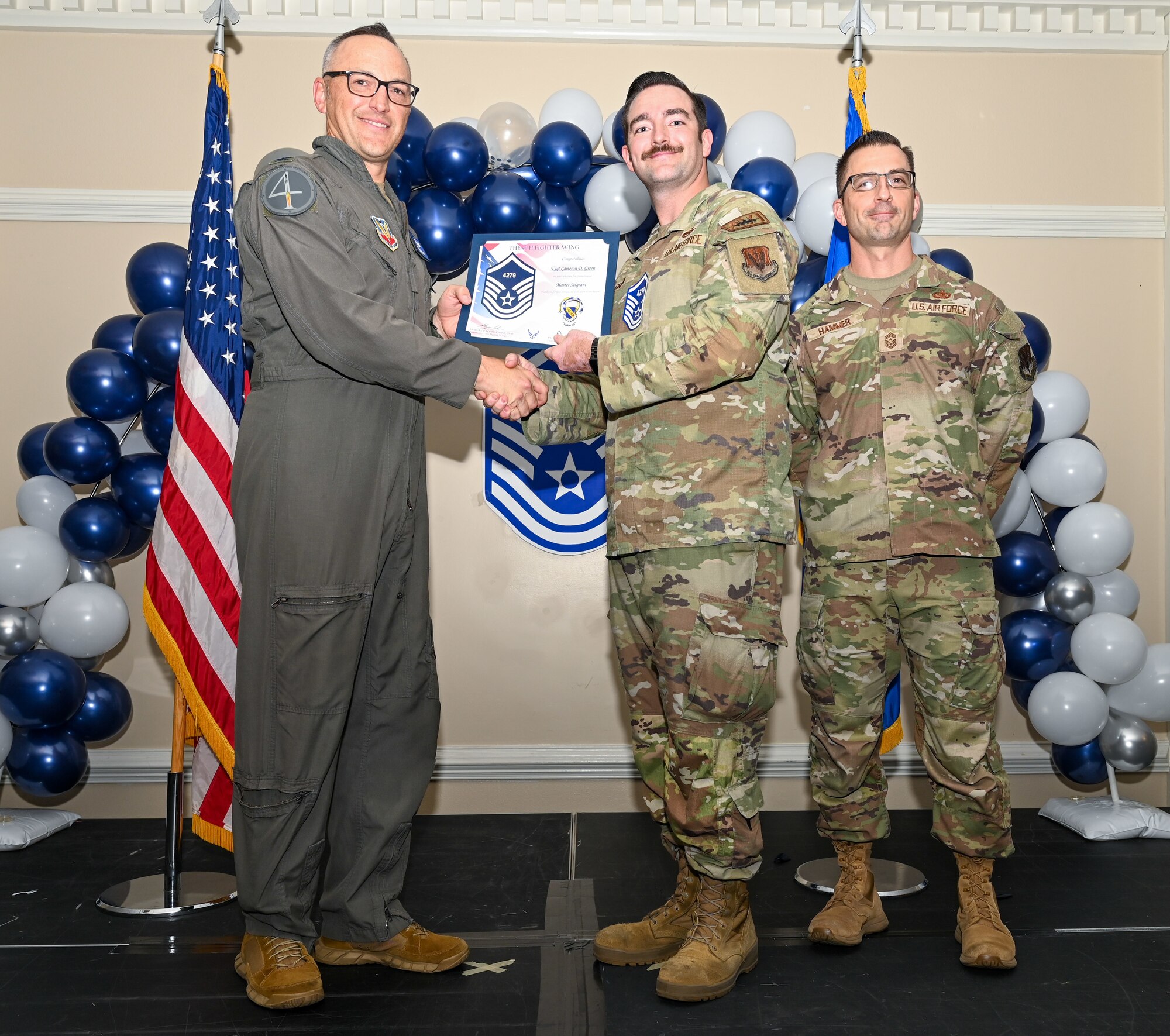 U.S. Air Force Col. Steven Bofferding, 4th Fighter Wing deputy commander (left), and Chief Master Sgt. Paul Hammer, 4 FW command chief, present a certificate to Master Sgt. select Cameron Green (center), 335th Fighter Generation Squadron avionics technician, during a Master Sergeant Release Ceremony at Seymour Johnson Air Force Base, North Carolina, June 6, 2024. A total of 5,500 Airmen were promoted among a pool of 29,497 across the Air Force. (U.S. Air Force photo by Airman Rebecca Tierney)