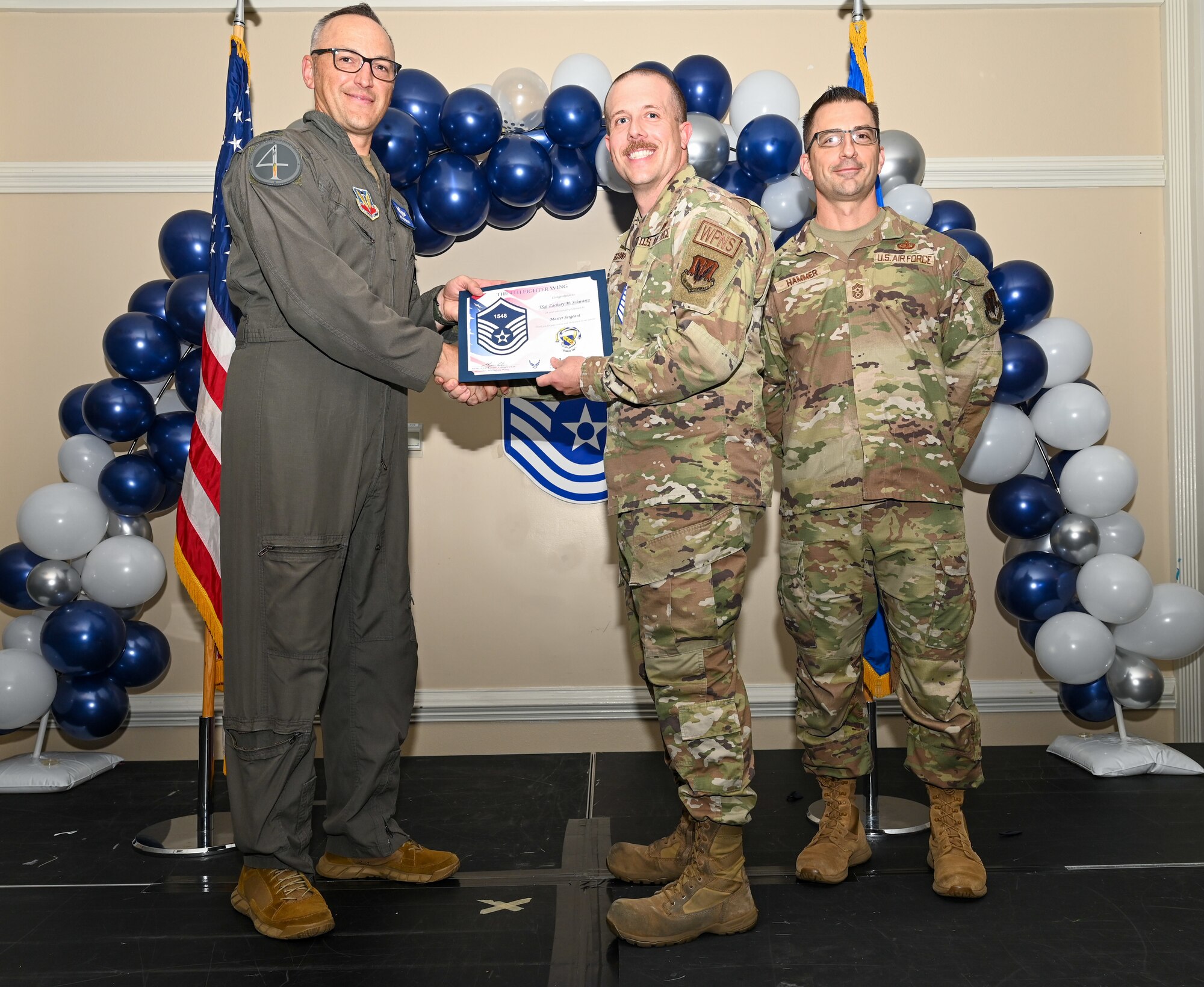 U.S. Air Force Col. Steven Bofferding, 4th Fighter Wing deputy commander (left), and Chief Master Sgt. Paul Hammer, 4 FW command chief, present a certificate to Master Sgt. select Zachary Schwartz (center), 336th Fighter Generation Squadron weapons expediter, during a Master Sergeant Release Ceremony at Seymour Johnson Air Force Base, North Carolina, June 6, 2024. The ceremony recognized the selectee’s new accomplishment of senior non-commissioned officer. (U.S. Air Force photo by Airman Rebecca Tierney)