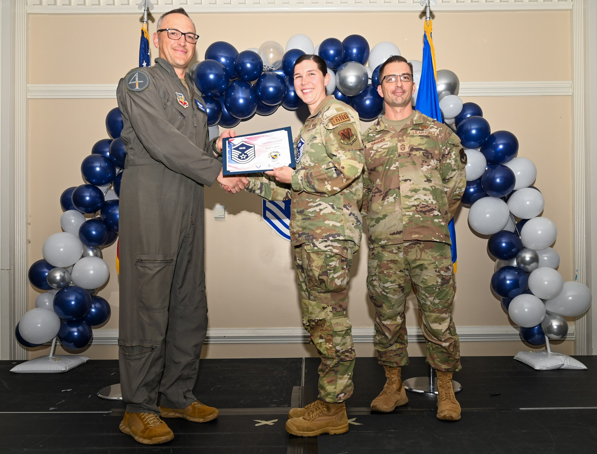 U.S. Air Force Col. Steven Bofferding, 4th Fighter Wing deputy commander (left), and Chief Master Sgt. Paul Hammer, 4 FW command chief, present a certificate to Master Sgt. select Alysha Henzler (center), 4th Maintenance Group training scheduler, during a Master Sergeant Release Ceremony at Seymour Johnson Air Force Base, North Carolina, June 6, 2024. A total of 5,500 Airmen were promoted among a pool of 29,497 across the Air Force. (U.S. Air Force photo by Airman Rebecca Tierney)