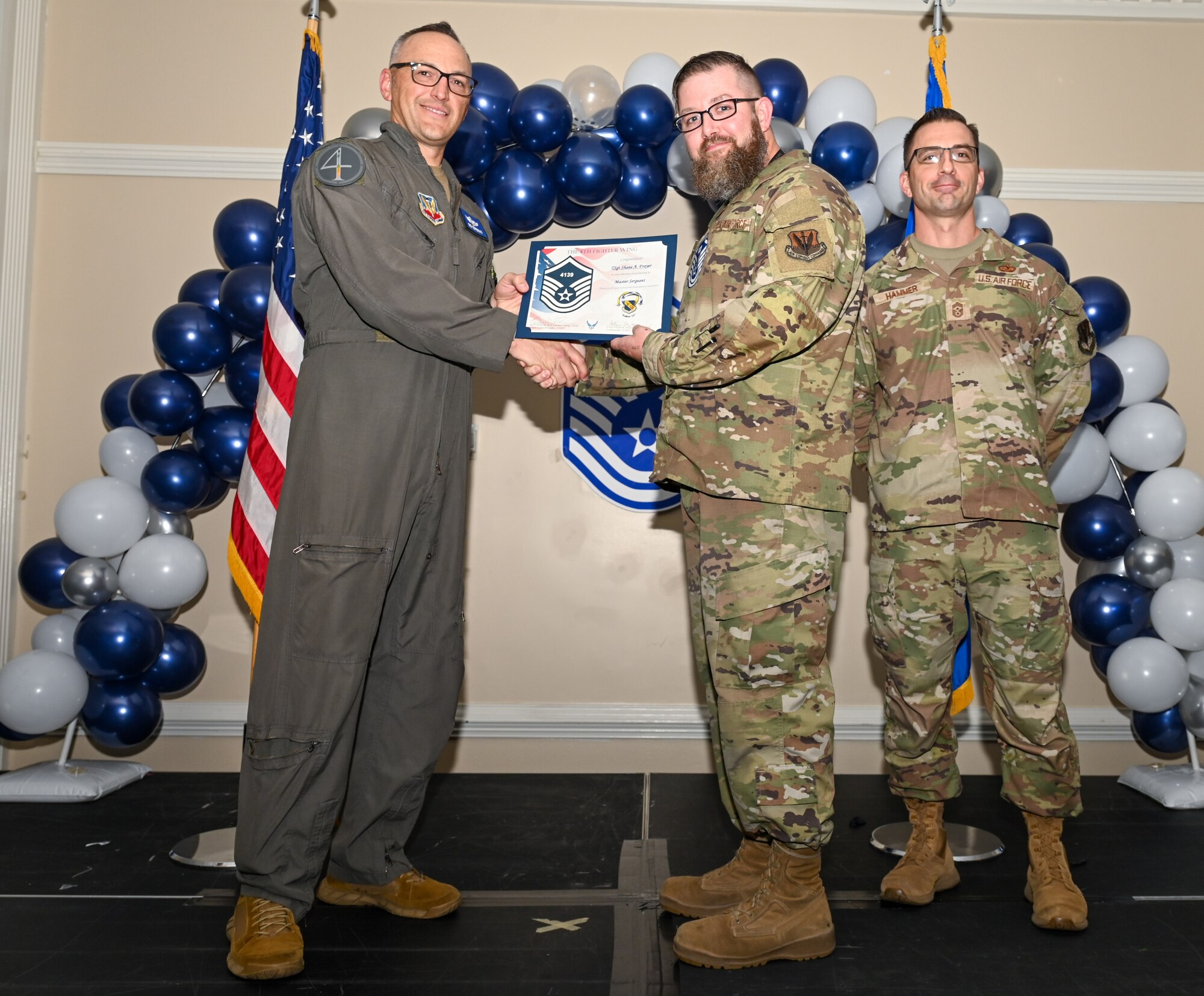 U.S. Air Force Col. Steven Bofferding, 4th Fighter Wing deputy commander (left), and Chief Master Sgt. Paul Hammer, 4 FW command chief, present a certificate to Master Sgt. select Tyler Dudley (center), 4th Security Forces Squadron flight chief, during a Master Sergeant Release Ceremony at Seymour Johnson Air Force Base, North Carolina, June 6, 2024. The ceremony recognized the selectee’s new accomplishment of senior non-commissioned officer. (U.S. Air Force photo by Airman Rebecca Tierney)