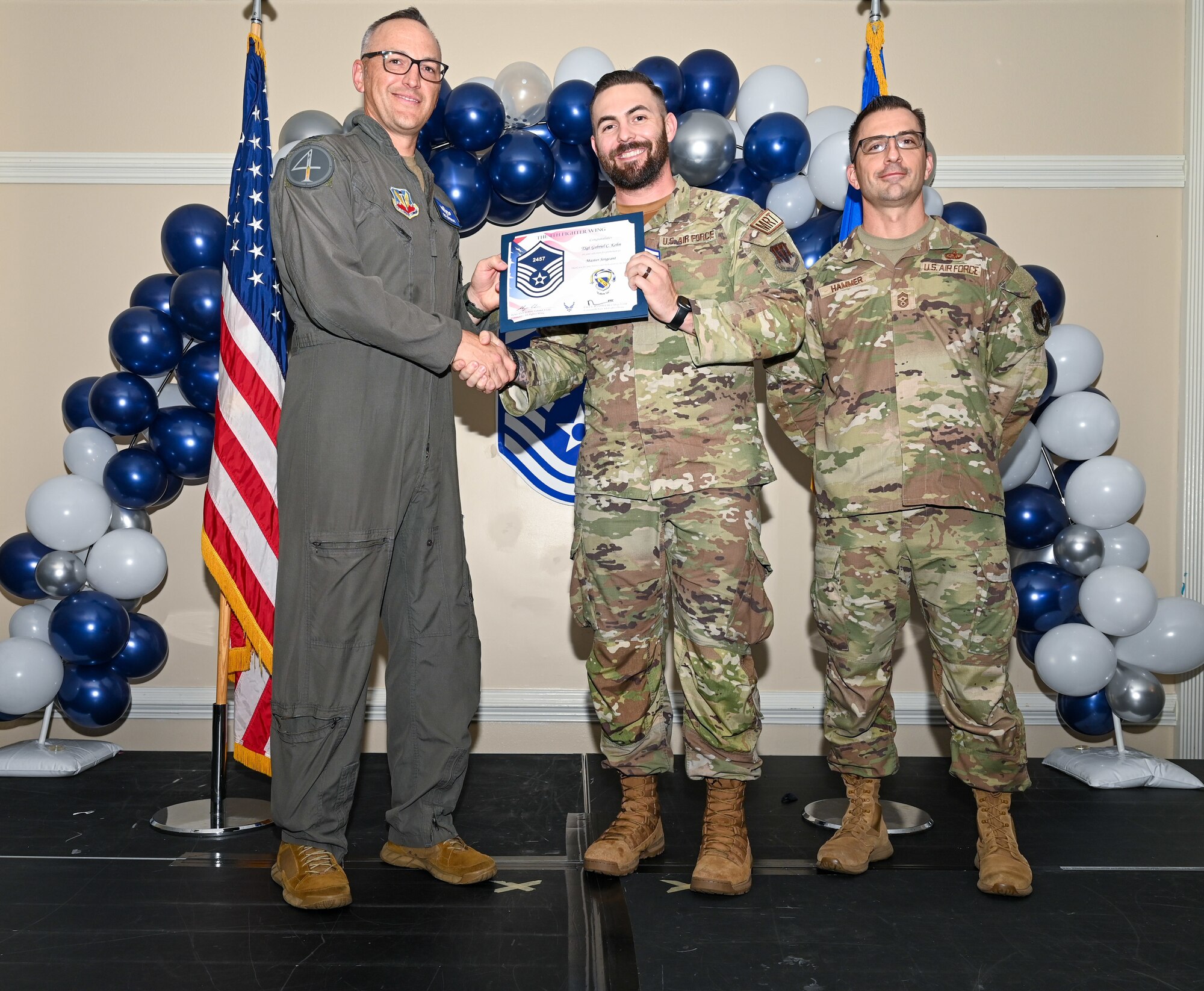 U.S. Air Force Col. Steven Bofferding, 4th Fighter Wing deputy commander (left), and Chief Master Sgt. Paul Hammer, 4 FW command chief, present a certificate to Master Sgt. select Tyler Dudley (center), 4th Security Forces Squadron flight chief, during a Master Sergeant Release Ceremony at Seymour Johnson Air Force Base, North Carolina, June 6, 2024. The ceremony recognized the selectee’s new accomplishment of senior non-commissioned officer. (U.S. Air Force photo by Airman Rebecca Tierney)