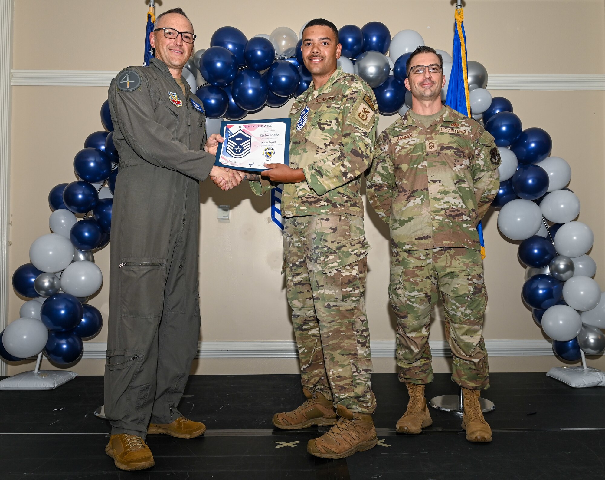 U.S. Air Force Col. Steven Bofferding, 4th Fighter Wing deputy commander (left), and Chief Master Sgt. Paul Hammer, 4 FW command chief, present a certificate to Master Sgt. select Tyler Dudley (center), 4th Security Forces Squadron flight chief, during a Master Sergeant Release Ceremony at Seymour Johnson Air Force Base, North Carolina, June 6, 2024. The ceremony recognized the selectee’s new accomplishment of senior non-commissioned officer. (U.S. Air Force photo by Airman Rebecca Tierney)