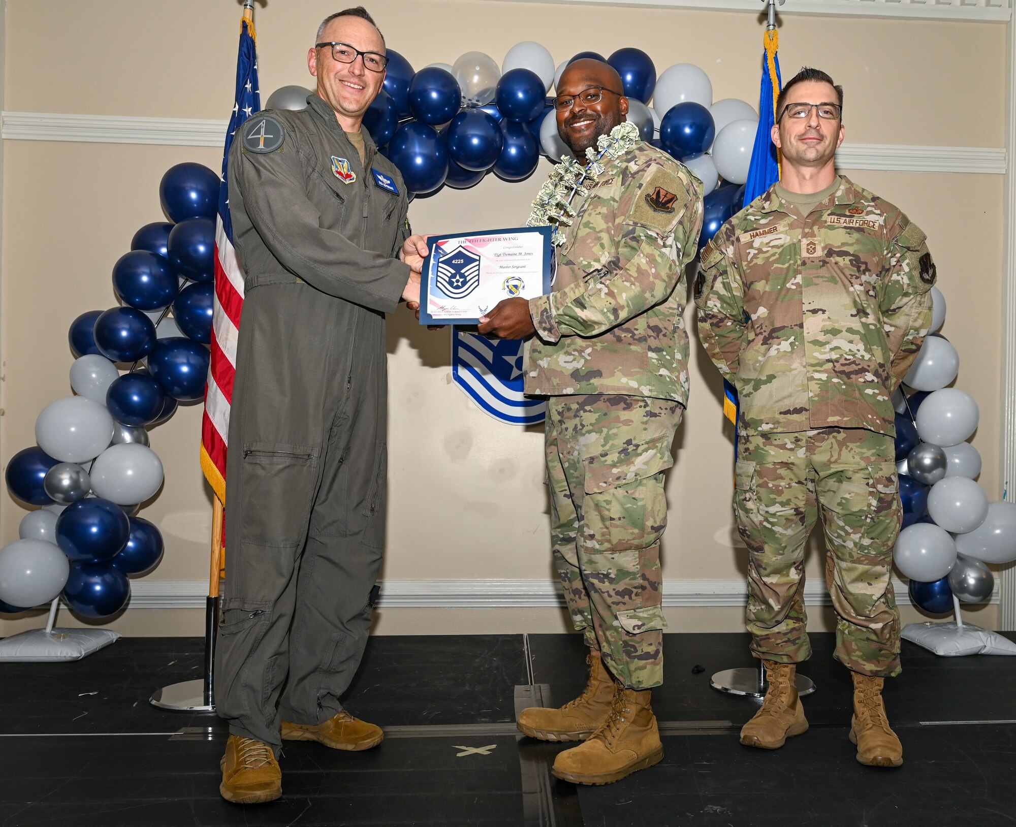 U.S. Air Force Col. Steven Bofferding, 4th Fighter Wing deputy commander (left), and Chief Master Sgt. Paul Hammer, 4 FW command chief, present a certificate to Master Sgt. select Tremaine Jones (center), 4th Medical Group supply operations section chief, during a Master Sergeant Release Ceremony at Seymour Johnson Air Force Base, North Carolina, June 6, 2024. The ceremony recognized the selectee’s new accomplishment of senior non-commissioned officer. (U.S. Air Force photo by Airman Rebecca Tierney)