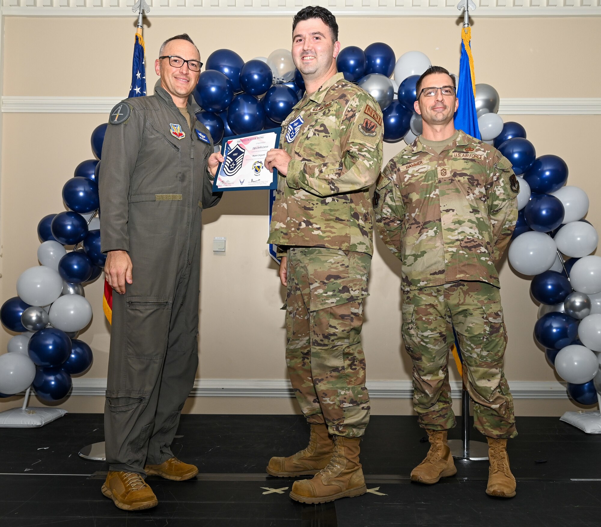 U.S. Air Force Col. Steven Bofferding, 4th Fighter Wing deputy commander (left), and Chief Master Sgt. Paul Hammer, 4 FW command chief, present a certificate to Master Sgt. select Charlie Cuevas (center), 4th Equipment Maintenance Squadron assistant 1st Sergeant, during a Master Sergeant Release Ceremony at Seymour Johnson Air Force Base, North Carolina, June 6, 2024. A total of 5,500 Airmen were promoted among a pool of 29,497 across the Air Force. (U.S. Air Force photo by Airman Rebecca Tierney)