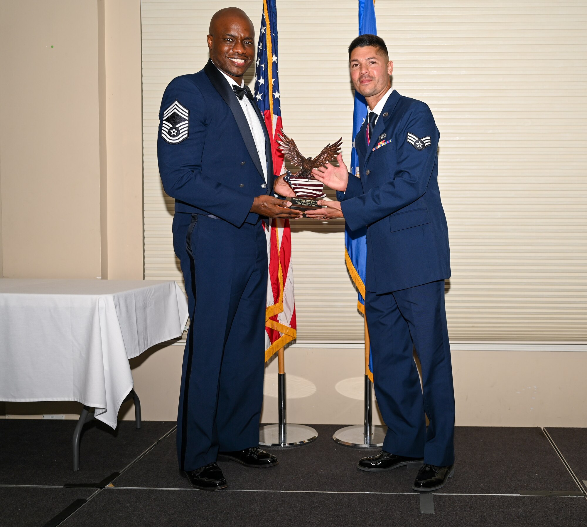 U.S. Air Force Senior Airman Danilo Artigo, 567th RED HORSE Squadron civil engineer customer service representative, right, accepts the John L. Levitow Award from Chief Master Sgt. Brenton Williams, 4th Maintenance Group wing weapons manager, during the ALS class 24-E graduation ceremony at Seymour Johnson Air Force Base, North Carolina, June 27, 2024. The John L. Levitow Award is the highest honor that can be earned by an Enlisted Professional Military Education graduate. (U.S. Air Force photo by Airman Rebecca Tierney)