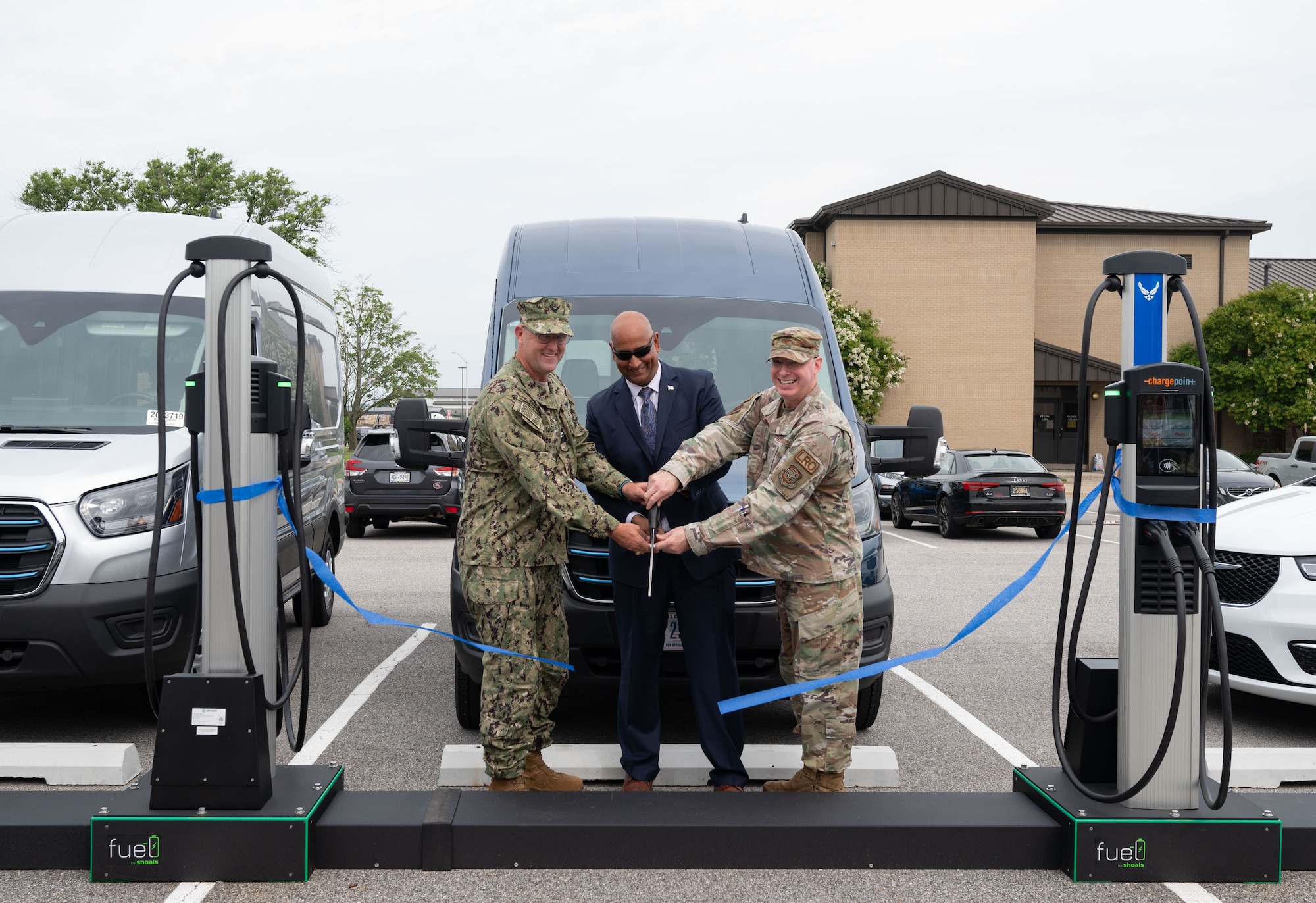 U.S. Navy Capt. Newt McKissick, left, Energy Portfolio at the Department of Defense Defense Innovation Unit deputy director, Dr. Ravi Chaudhary, center, U.S. Air Force Energy, Installations and Environment assistant secretary and U.S. Air Force Col. Chris McDonald, 436th Airlift Wing commander, cut the ribbon for the new electric vehicle chargers at Dover Air Force Base, Delaware, July 22, 2024.  Dover AFB is one of two pilot bases to receive EV government-owned vehicles and the first to construct EV chargers on base – one of the first steps to achieve 100% zero emission vehicles acquisition by 2035 according to executive order 14057. (U.S. Air Force photo by Airman Liberty Matthews)