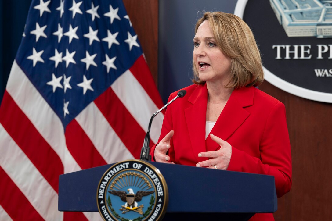 Deputy Defense Secretary Kathleen Hicks speaks at a lectern with the American flag and Pentagon seal in the background.