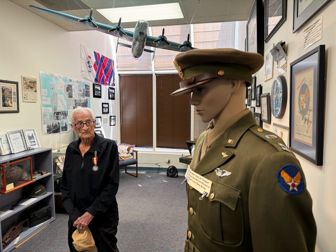 A person standing next to a mannequin in a military uniform