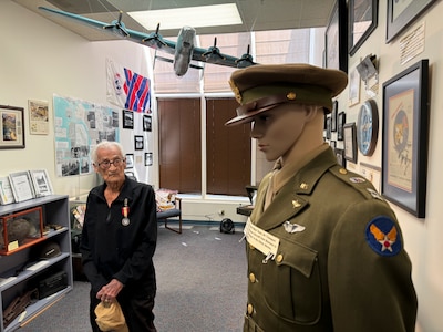 A person standing next to a mannequin in a military uniform