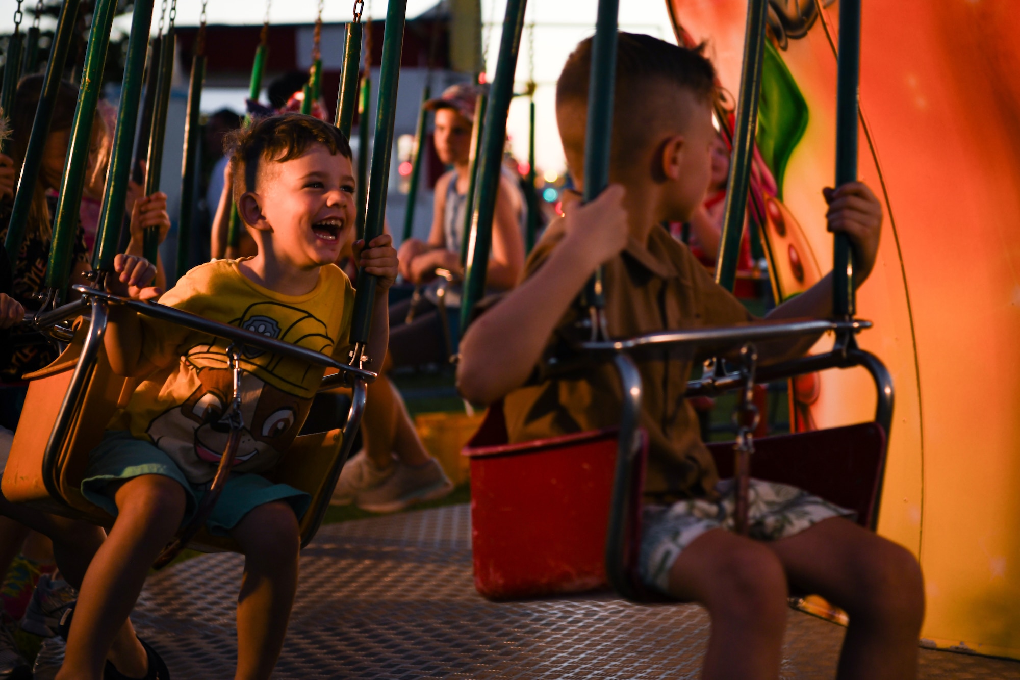 A child gleefully enjoys an amusement park ride.