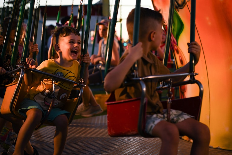 A child gleefully enjoys an amusement park ride.