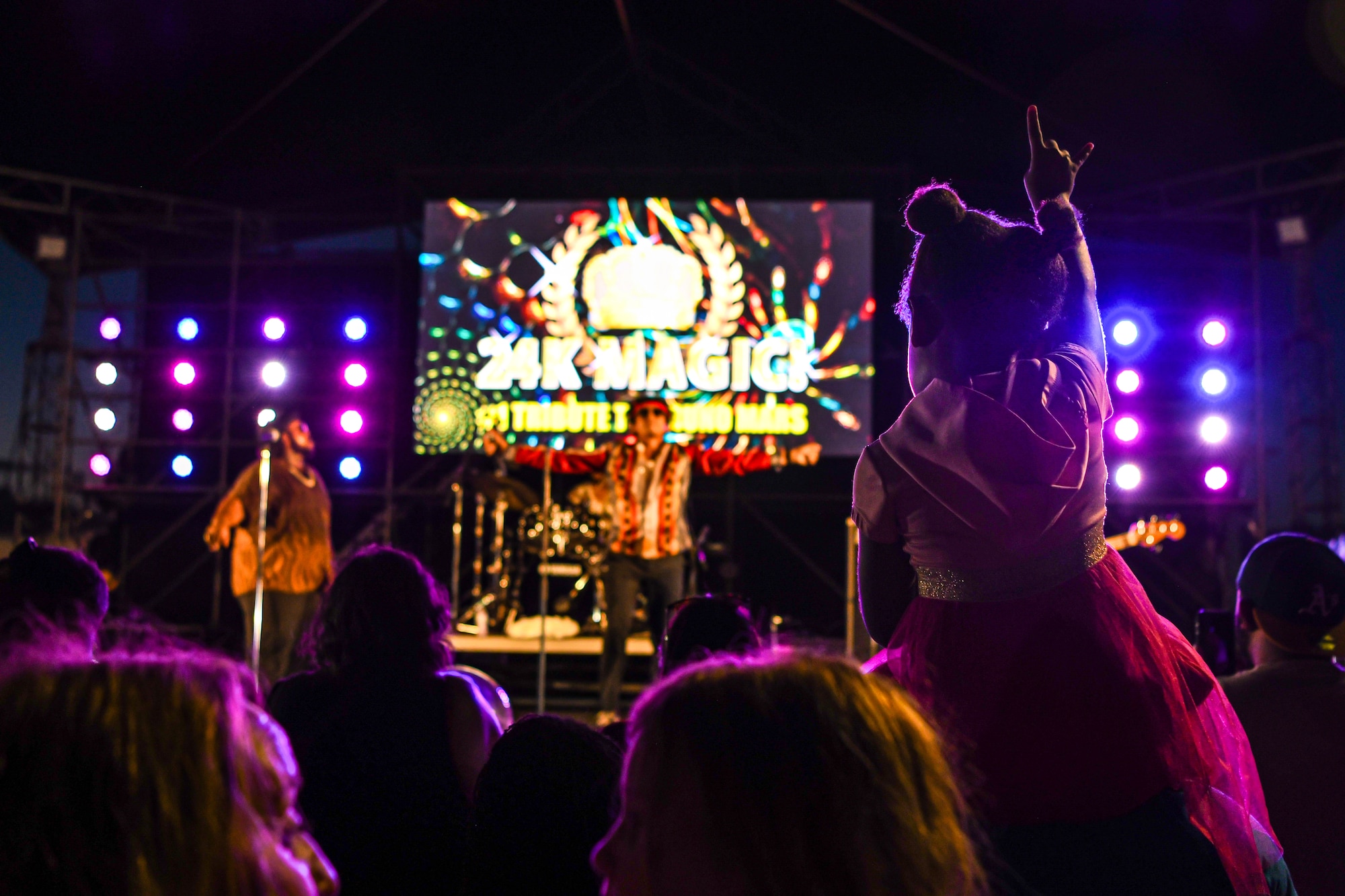A child rocks out to a tribute band.