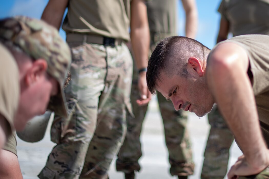 military members kneeled down on cement