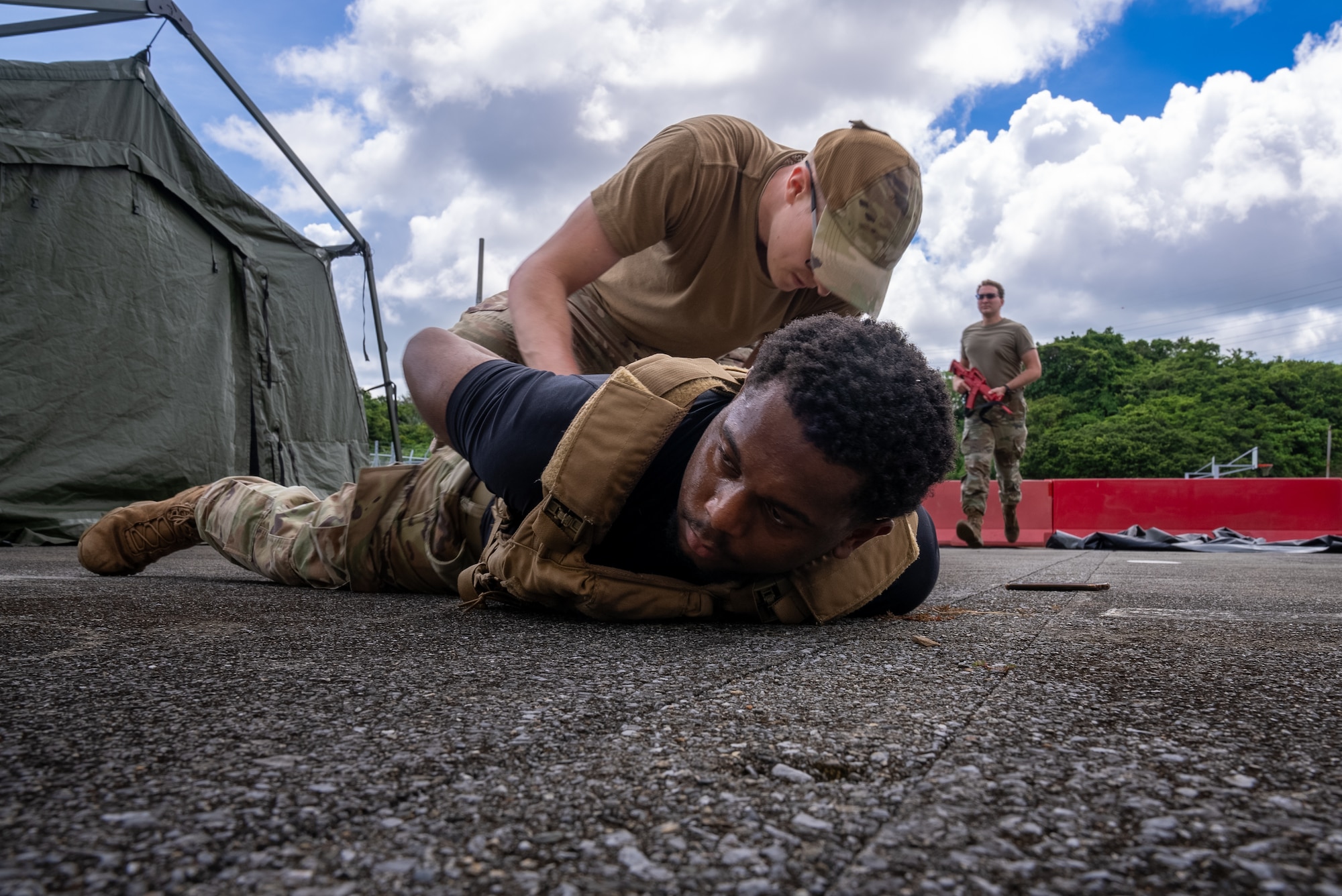 airman tackles another airman to the ground as a simulated attack