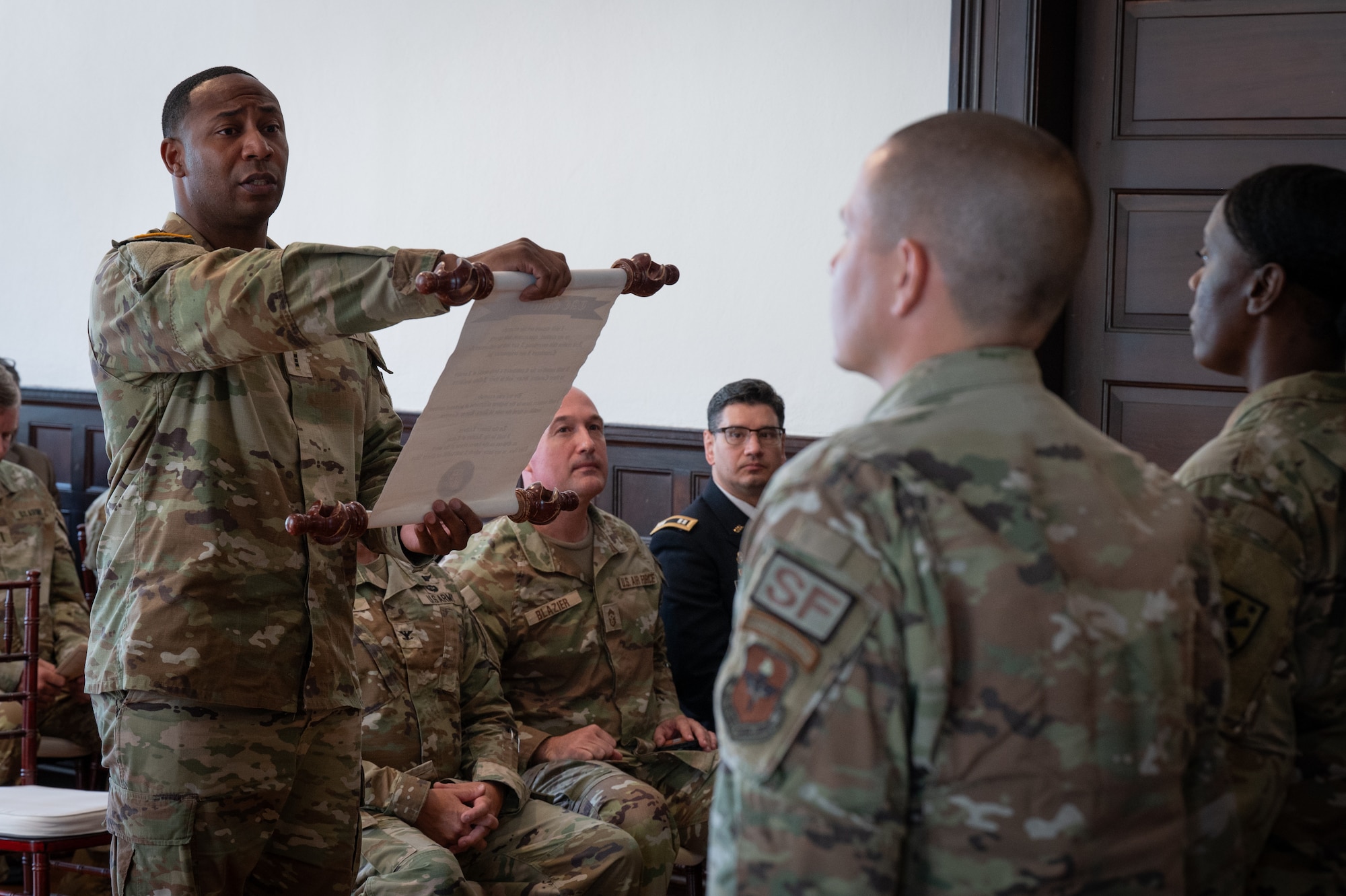 Graduates of the Train, Advise and Counsel Officer Certification Course, recite the TAC Officer Creed during a graduation ceremony at the Holman House in Ozark, Alabama, July 19, 2024. The knowledge and skills acquired by the graduating Airmen are set to revolutionize the curriculum at the new U.S. Air Force Warrant Officer School. (U.S. Air Force photo by Senior Airman Evan Porter)