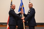 The new commander receives the guidon on stage.
