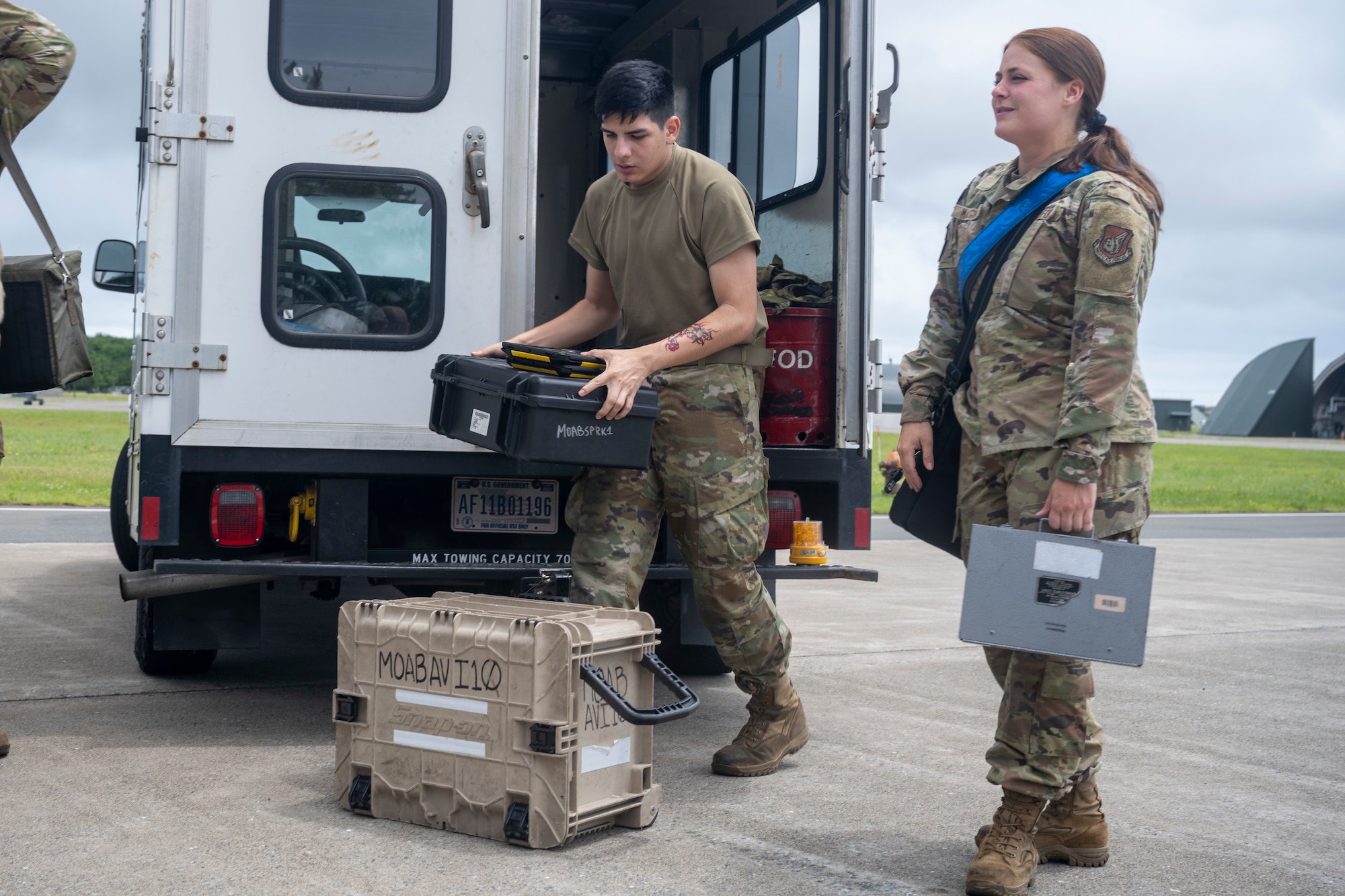 U.S. Air Force Airman 1st Class Danial Arias, left, and Senior Airman Sara Macgowan, right, 13th Fighter Generation Squadron F-16 avionics journeymen, unload supplies during a Wild Weasel Walkthrough at Misawa Air Base, Japan, July 11, 2024.