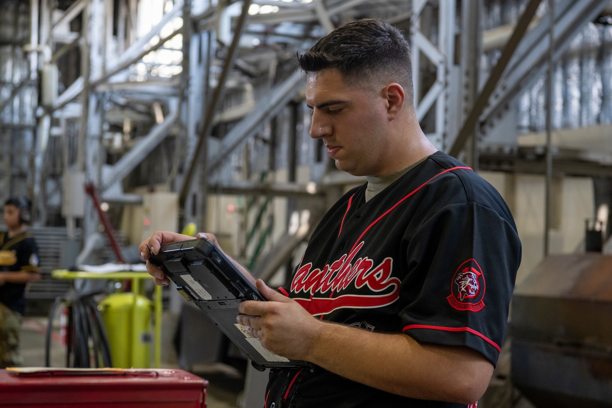 U.S. Air Force Staff Sgt. Brandon Harman, 13th Fighter Generation Squadron  load crew team chief, examines a tablet during the 35th Maintenance Group’s 2nd quarter weapons load competition at Misawa Air Base, Japan, July 18, 2024.