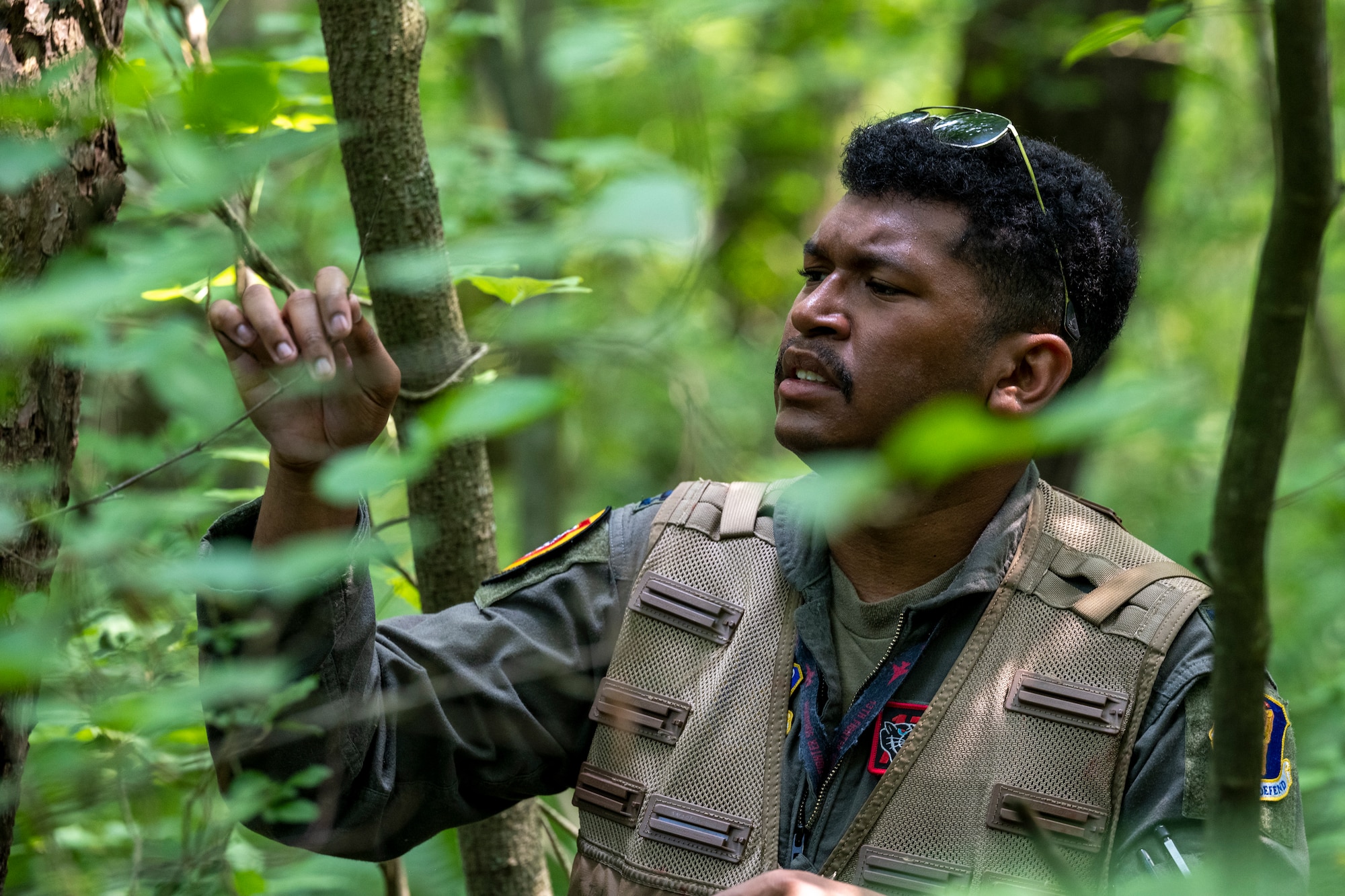 U.S. Air Force Capt. Isaiah Butcher, 13th Fighter Squadron pilot, examines branches for kindling during a Combat Survival Training exercise led by Survival, Evasion, Resistance, Escape (SERE) specialists at Draughon Range near Misawa Air Base, Japan, July 16, 2024.
