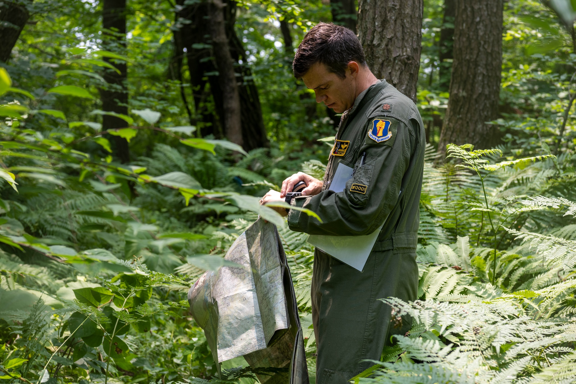 U.S. Air Force Maj. Bradford Waldie, 14th Fighter Squadron pilot, examines a map and GPS during a Combat Survival Training exercise led by Survival, Evasion, Resistance, Escape (SERE) specialists at Draughon Range near Misawa Air Base, Japan, July 16, 2024.