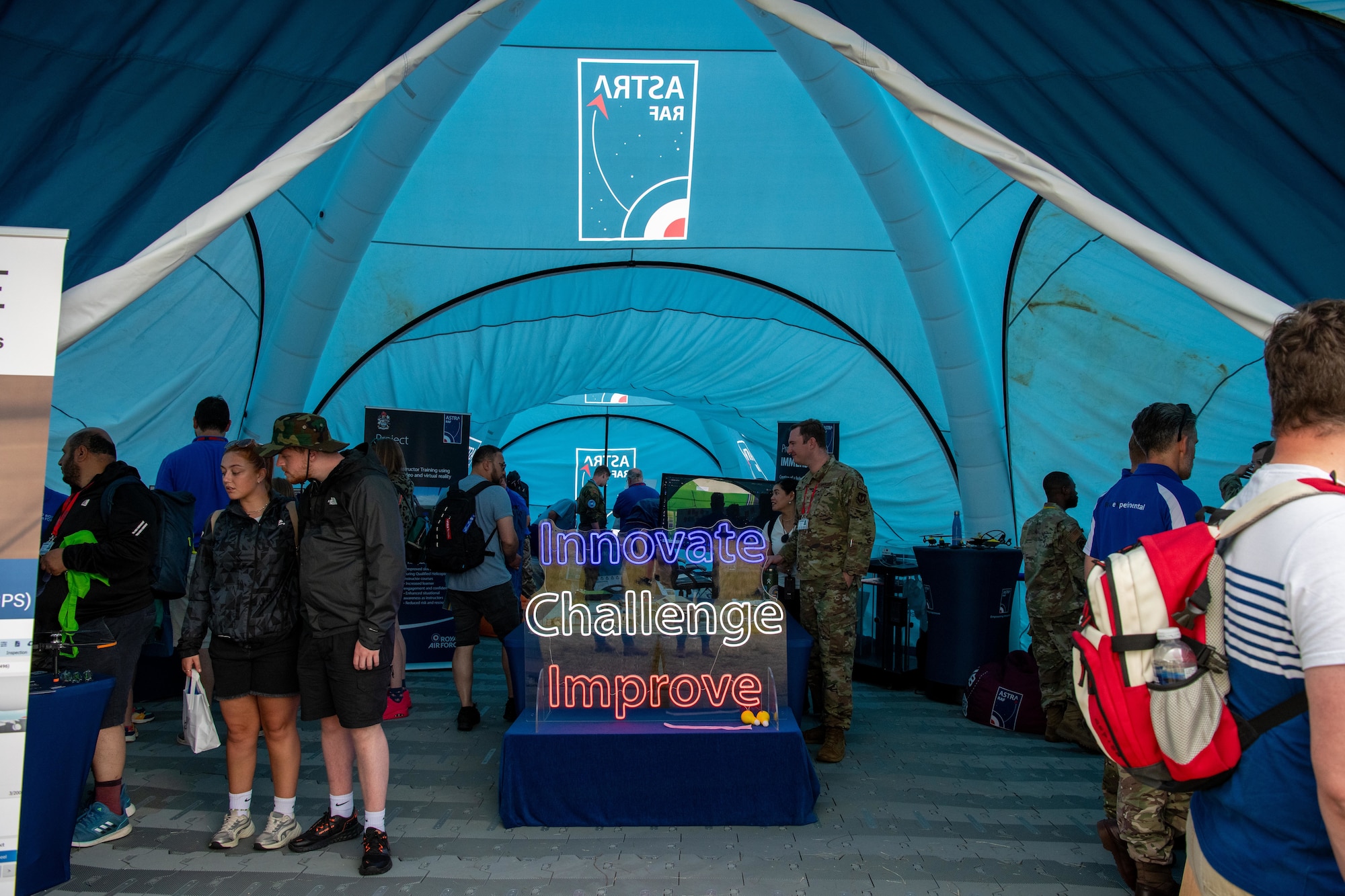 A sign reading “INNOVATE CHALLENGE IMPROVE” is displayed in the RAF Astra