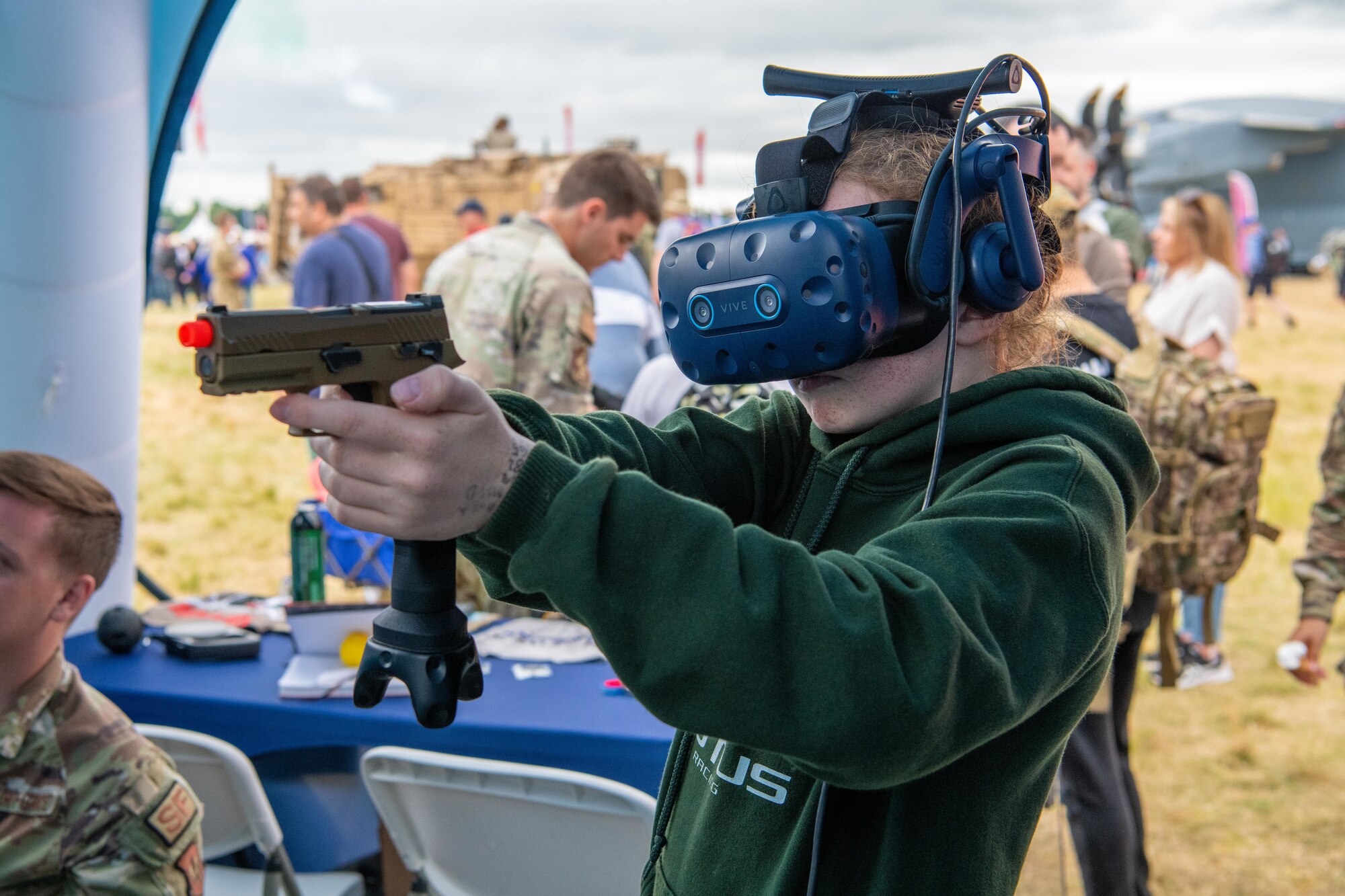 A participant wears a virtual reality headset showing a security forces simulation