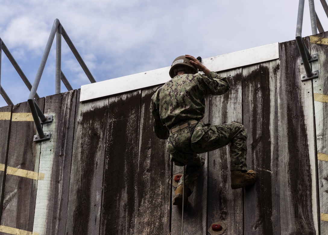 A Naval Reserve Officer Training Corps (NROTC) Midshipman climbs down a rock wall during during the annual Midshipmen summer training on Camp Lejeune, North Carolina, July 18, 2024. This training is conducted annually to develop and train future commissioned officers and provides them with an opportunity to gain experience in the practical application of the Fleet Marine Force. (U.S. Marine Corps photo by Cpl. Noelia Vazquez)