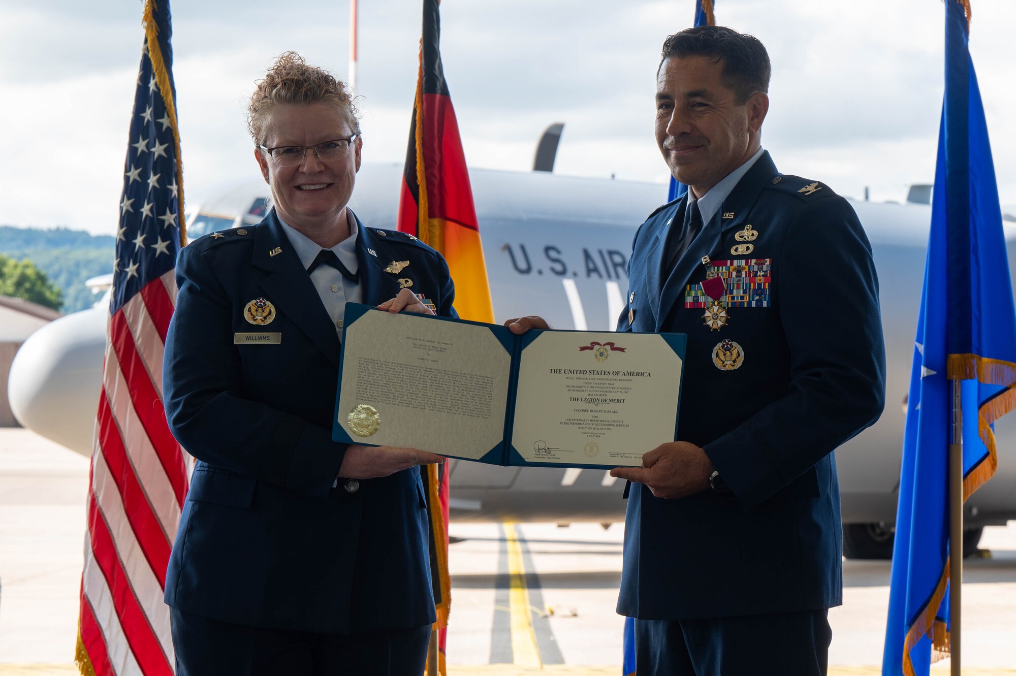 86th AW commander presents Legion of Merit certificate to outgoing MXG commander.