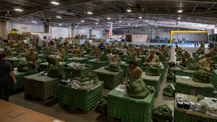 Airmen in a room with deployment kits