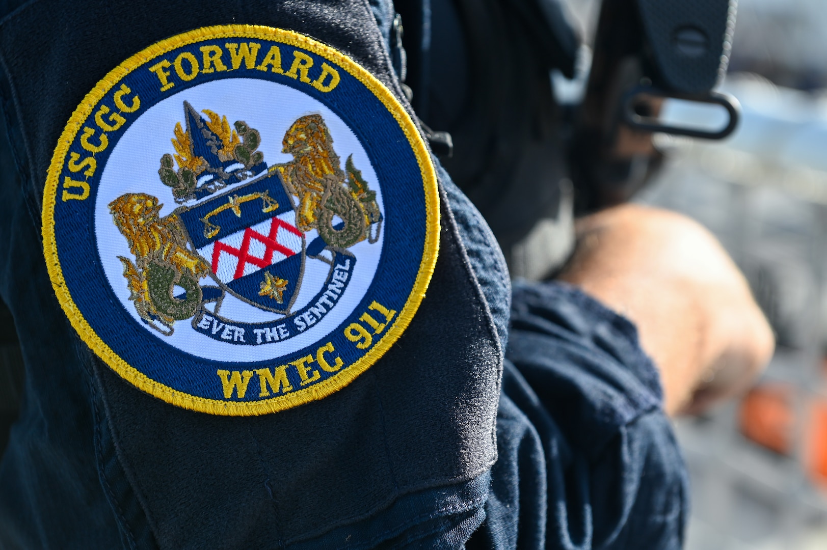 A detail shot of the Coast Guard Cutter Forward's emblem on a crew member standing watch over illicit narcotics at Port Everglades, Florida, July 22, 2024. The cutter Forward is a 270 foot famous-class cutter home ported in Portsmouth, Virginia. (U.S. Coast Guard photo by Petty Officer 3rd Class Nicholas Strasburg)