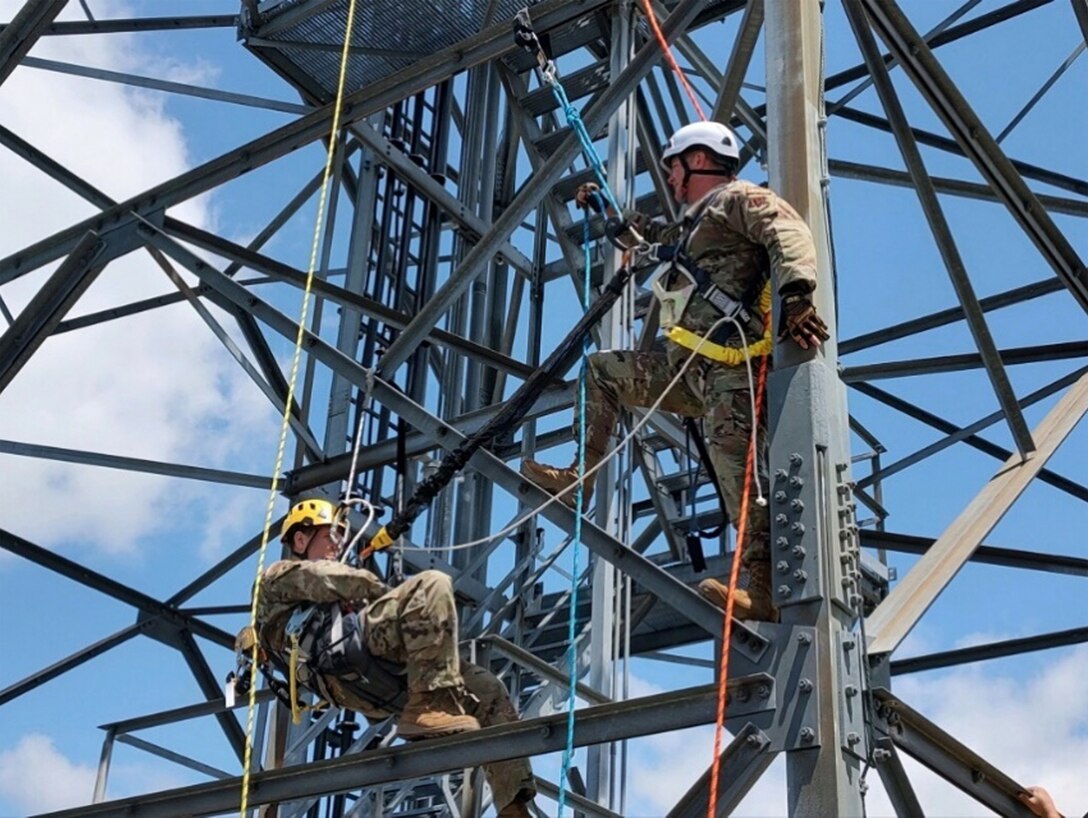 Pennsylvania Air National Guardsmen Staff Sgt. Jeremiah Leonard, left, and Tech. Sgt. Shane Miller, right, with the 258th Air Traffic Control Squadron in Johnstown, Pennsylvania, prepare to train on a pick-off rescue while on a radar tower during their two-week training exercise from June 3, 2024 to June 16, 2024.