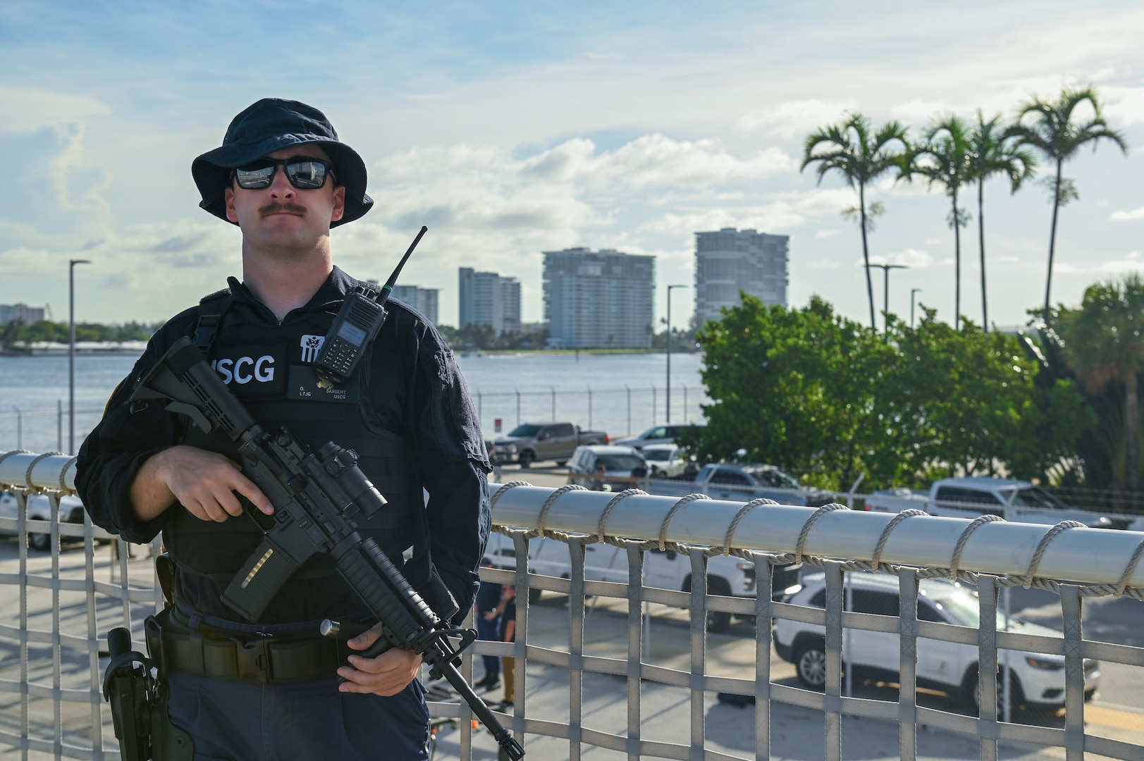 A crew member of the Coast Guard Cutter Forward standing watch over illegal narcotics, Port Everglades, Florida, July 22, 2024. Armed Coast Guardsmen stand watch over interdicted drugs to ensure security and accountability of seized contraband. (U.S. Coast Guard photo by Petty Officer 3rd Class Nicholas Strasburg)