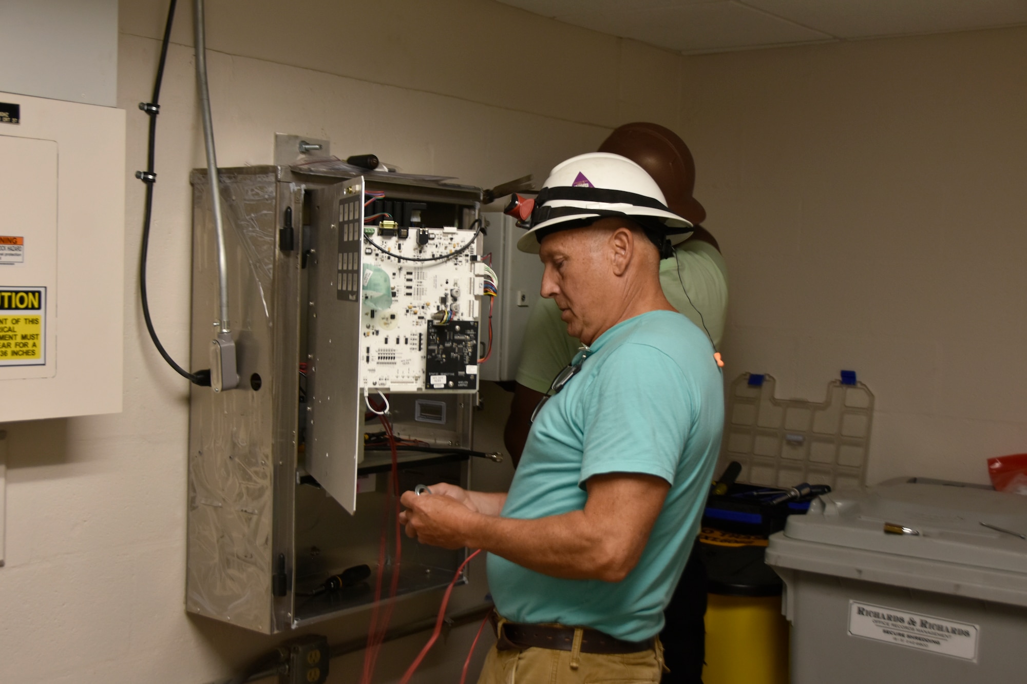 Russell Cain, left, and Tre Powell with Mobile Communications America install an indoor siren system in the von Kármán Gas Dynamics Facility at Arnold Air Force Base, Tenn., July 11, 2024. This work is part of an ongoing siren system upgrade project occurring at Arnold. When completed, 13 outdoor siren systems and 11 indoor siren systems located across the installation will be upgraded to improve the clarity of messages broadcast through the systems. These systems, collectively referred to as the Giant Voice System, transmit audible spoken messages, accompanied by sirens depending on the situation, whenever a situation that those across Arnold should be made aware of arises. These broadcasts can include alerts related to the weather, testing and emergency situations occurring on the installation. (U.S. Air Force photo by Bradley Hicks)