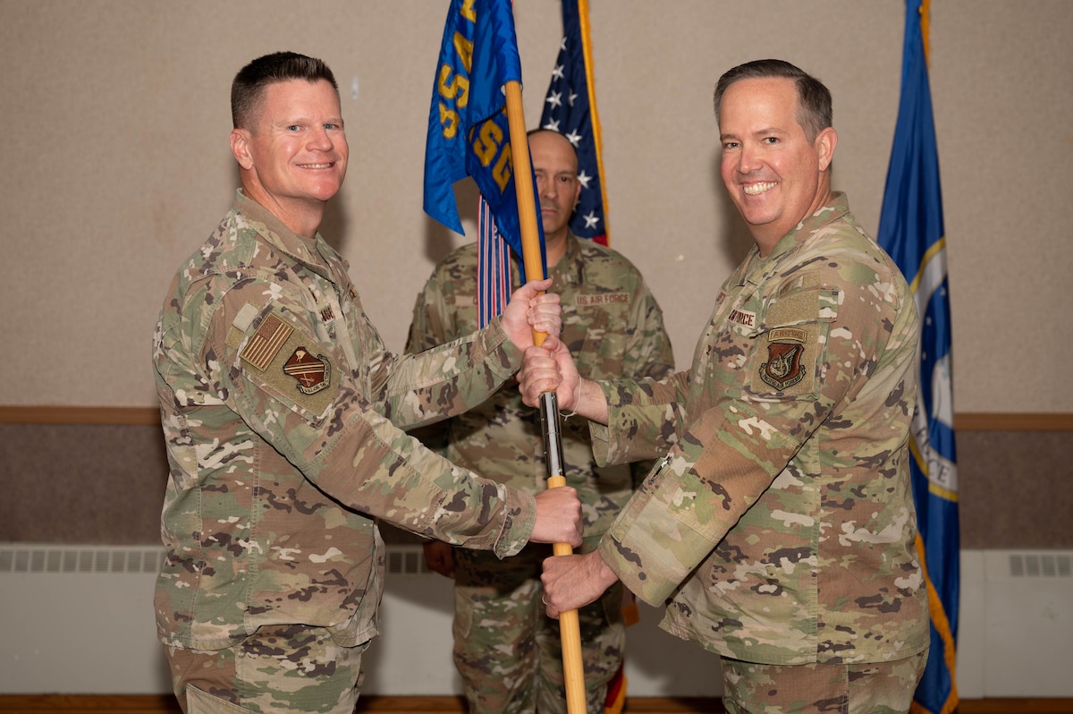 U.S. Air Force Col. Paul Townsend (left), 354th Fighter Wing commander, hands the guidon to Col. Timothy Foster, 354th Mission Support Group incoming commander, during the 354th MSG change of command ceremony at Eielson Air Force Base, Alaska, July 17, 2024.