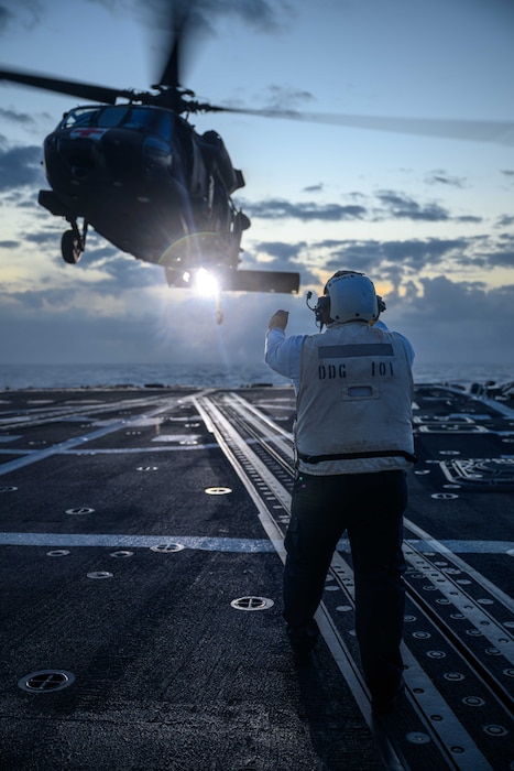 U.S. Navy Boatswain’s Mate 2nd Class John Delacuesta signals an approaching U.S. Army HH-60M Black Hawk helicopter, assigned to the “Hammerheads” of 3rd Battalion, 25th Aviation Regiment, as it prepares to land on the flight deck of the Arleigh Burke-class guided-missile destroyer USS Gridley (DDG 101) during Exercise Rim of the Pacific (RIMPAC) 2024, July 21.
