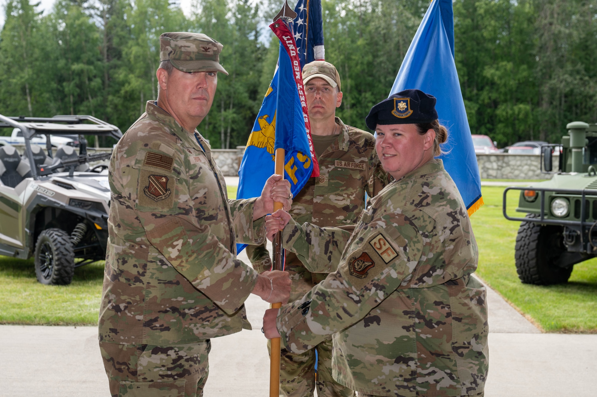 U.S. Air Force Col. Timothy Foster (left), 354th Mission Support Group commander, accepts the guidon from Maj. Autumne Ferrell, 354th Security Forces Squadron outgoing commander, during the 354th SFS change of command ceremony at Eielson Air Force Base, Alaska, July 18, 2024.