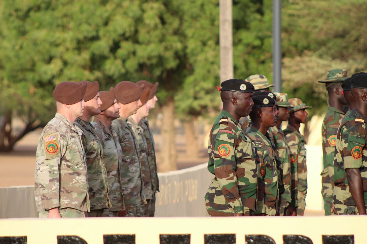 U.S. and Senegalese soldiers stand in formation outdoors at a ceremony.