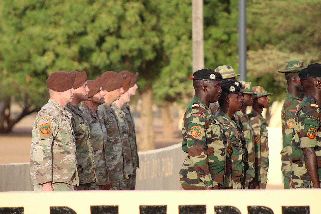 U.S. and Senegalese soldiers stand in formation outdoors at a ceremony.