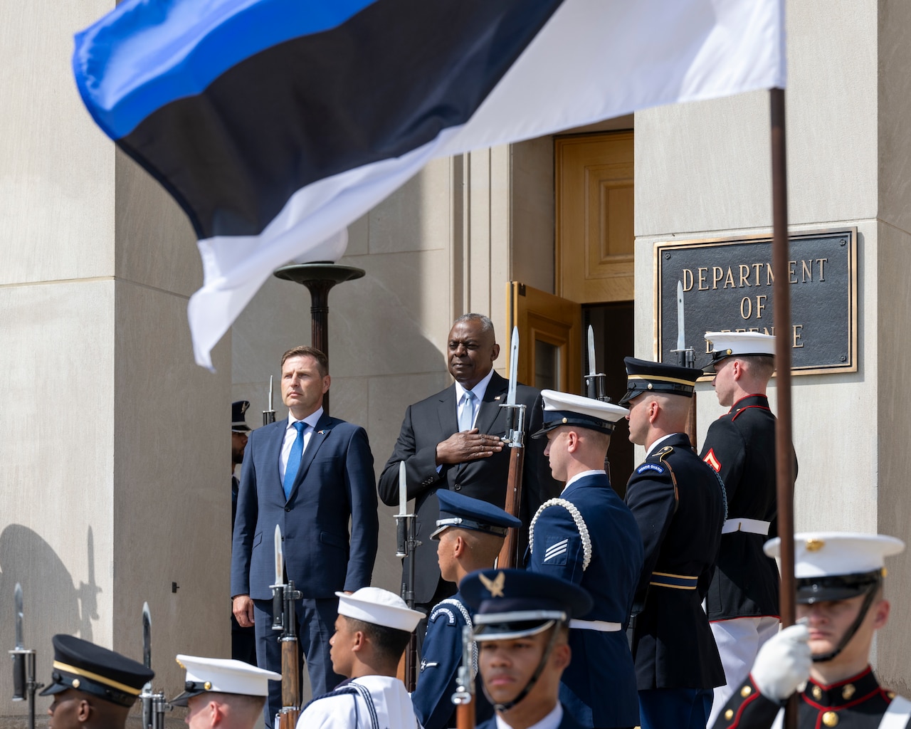Two men stand on the steps of the Pentagon during a ceremony.