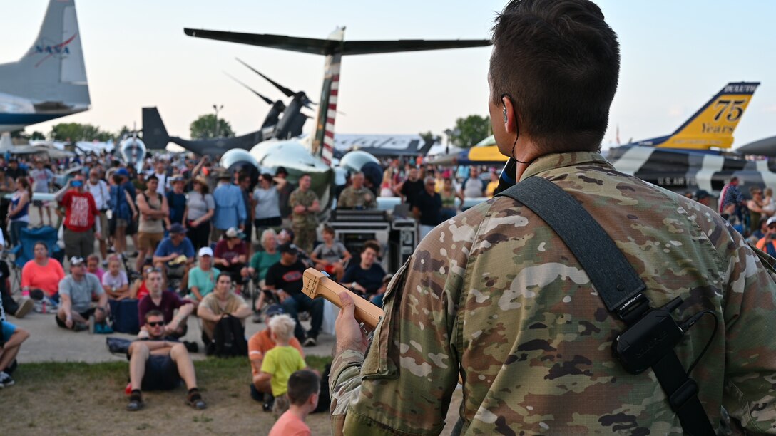 Air Force Guitarist plays in front of a crowd at the Oshkosh Air Show.