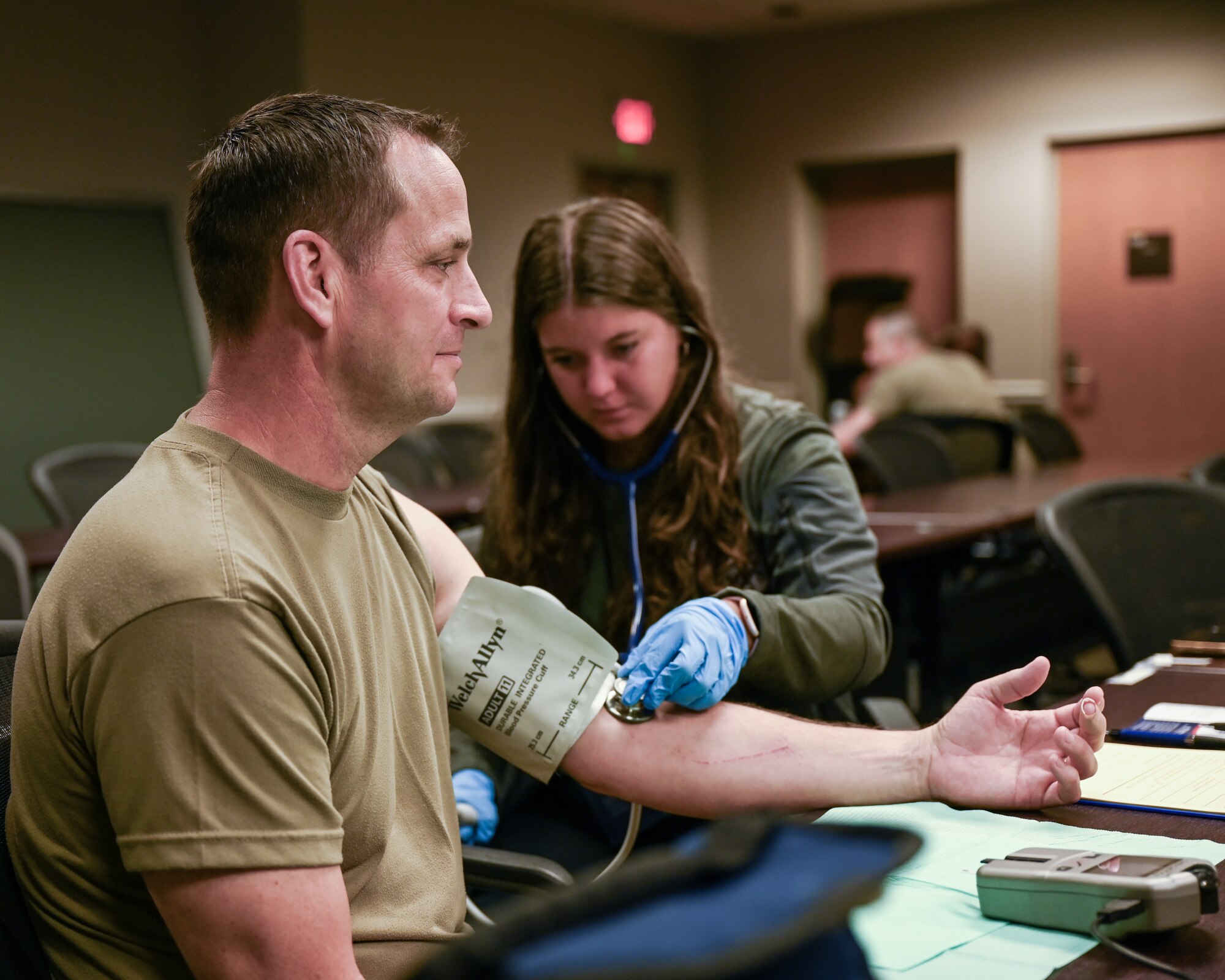 Olivia Lehman, a health promotion coordinator with Civilian Health Promotion Services, checks the blood pressure of Senior Master Sgt. Dennis Hartwick, 445th Maintenance Group quality assurance superintendent, during the annual Civilian Health Promotion Services Wellness Fair at Wright-Patterson Air Force Base, Ohio, July 17, 2024. During the event people were able to get information about physical health and were screened for cardiac risk, body composition analysis, and blood pressure. (U.S. Air Force photo by Master Sgt. Patrick OReilly)