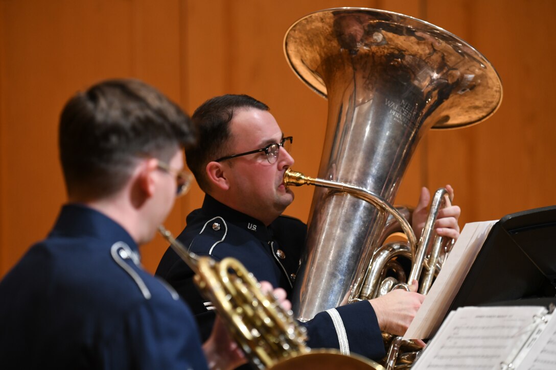 Air Force Tubaist performs in a concert hall.